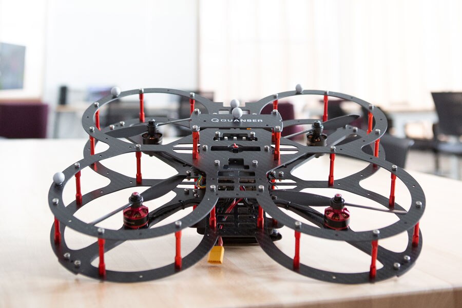 A drone sitting on a wooden desk.